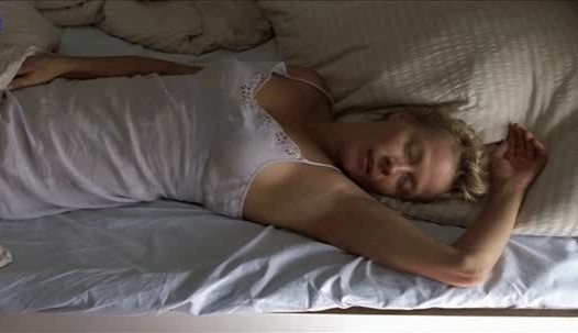 blond older lady with short hair touching herself under the covers. 